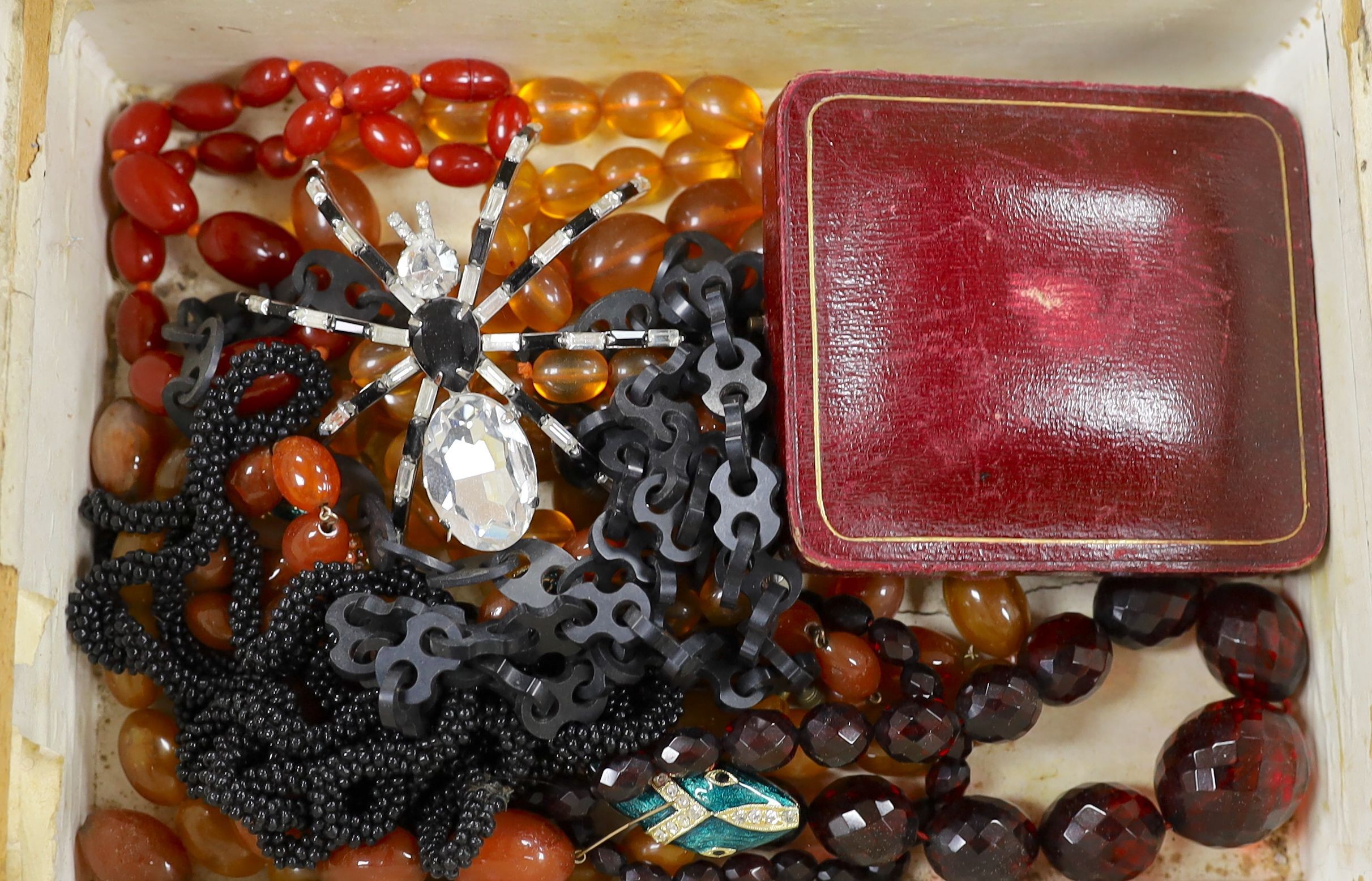 Mixed costume jewellery, including faux amber necklaces and paste set spider and serpent brooches, housed in a 19th century walnut work box.